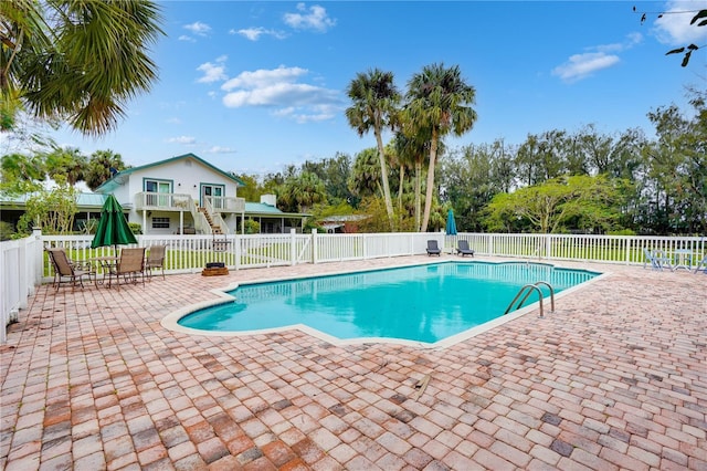 view of pool featuring a patio, stairway, fence, and a fenced in pool