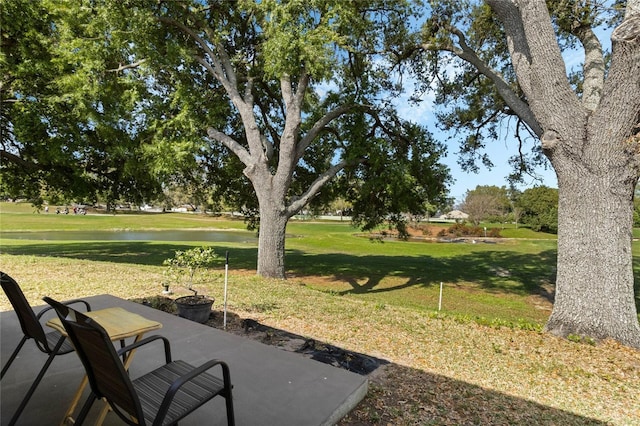 view of home's community featuring a patio, a yard, and a water view