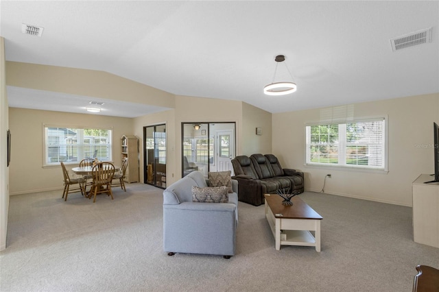 living room featuring visible vents, light carpet, and vaulted ceiling