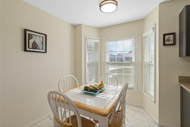 dining room with baseboards and marble finish floor