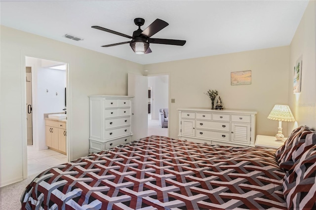 bedroom with visible vents, light carpet, ceiling fan, and ensuite bathroom