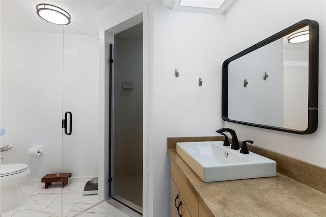 bathroom with vanity, toilet, marble finish floor, and a shower stall