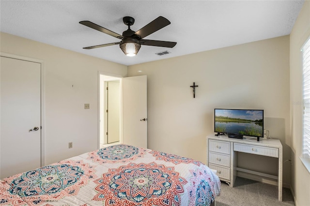 bedroom with light carpet, visible vents, and a ceiling fan