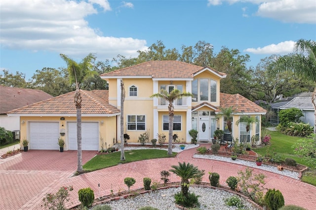 mediterranean / spanish-style house with a front lawn, stucco siding, decorative driveway, a garage, and a balcony