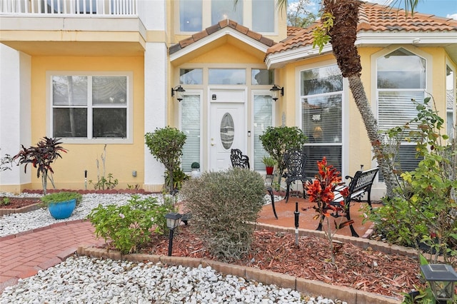 entrance to property with stucco siding and a tiled roof