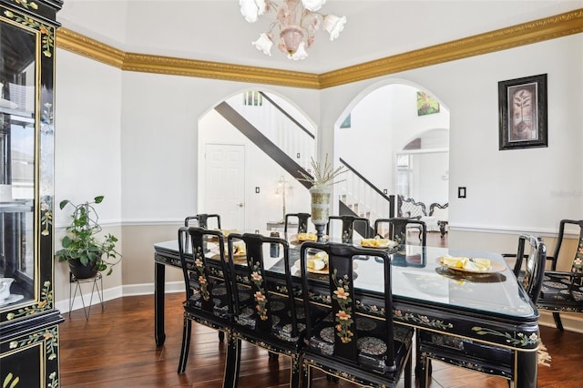 dining area featuring stairs, wood finished floors, arched walkways, and a chandelier