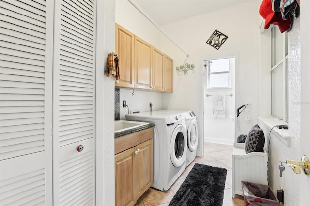 laundry area with light tile patterned floors, cabinet space, and washing machine and dryer