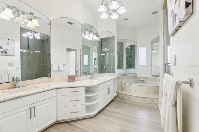 full bathroom featuring a notable chandelier, visible vents, a stall shower, and a sink