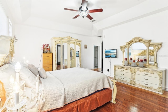 bedroom with visible vents, a raised ceiling, ceiling fan, and hardwood / wood-style flooring