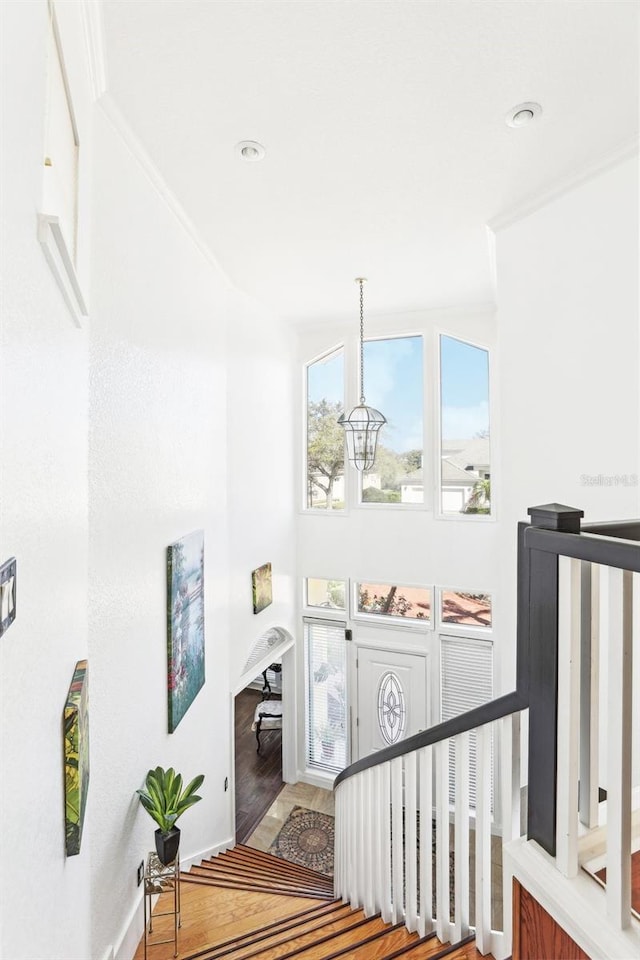 staircase with baseboards, wood finished floors, and crown molding