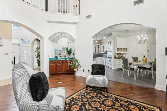 living area with visible vents, baseboards, and dark wood-style flooring