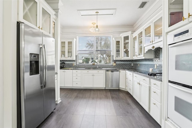 kitchen with dark wood-style floors, visible vents, a sink, stainless steel appliances, and tasteful backsplash