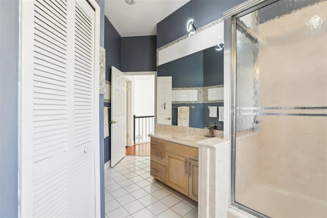 full bathroom featuring a closet, vanity, a shower stall, and tile patterned flooring