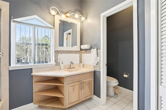 bathroom with baseboards, toilet, vanity, and tile patterned flooring