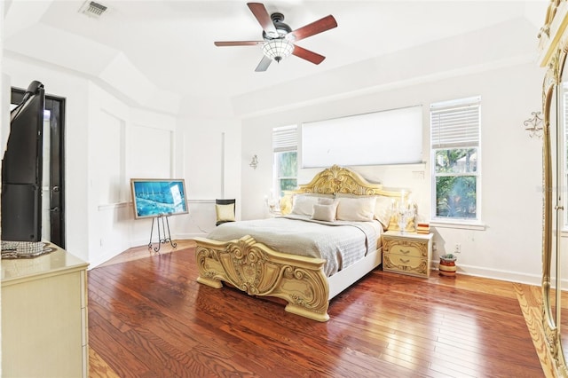 bedroom featuring visible vents, multiple windows, and hardwood / wood-style flooring