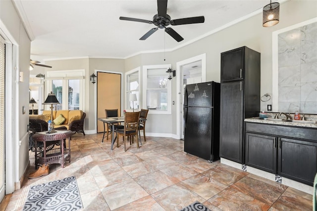 kitchen with a sink, ceiling fan, ornamental molding, freestanding refrigerator, and dark cabinets