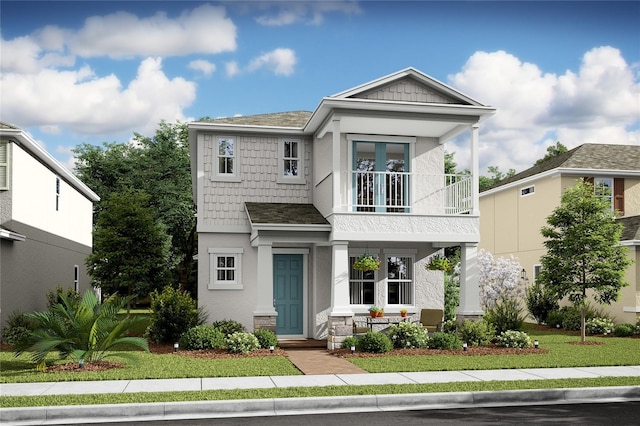 view of front facade with a front lawn, roof with shingles, a balcony, and stucco siding