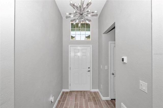 interior space with baseboards, a chandelier, and wood tiled floor