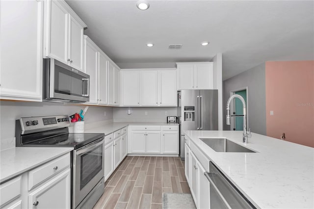 kitchen with white cabinets, visible vents, appliances with stainless steel finishes, and a sink