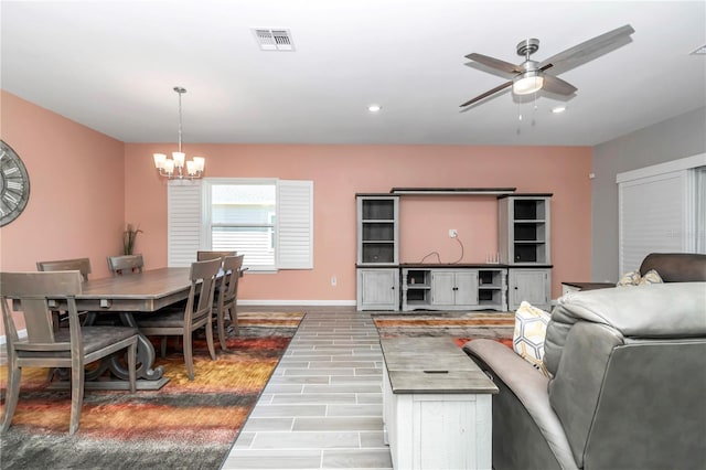 living area with visible vents, baseboards, wood tiled floor, recessed lighting, and ceiling fan with notable chandelier