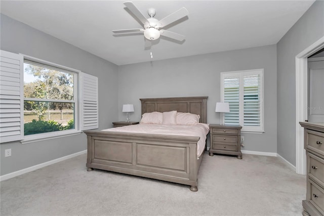 bedroom featuring baseboards, light colored carpet, and a ceiling fan