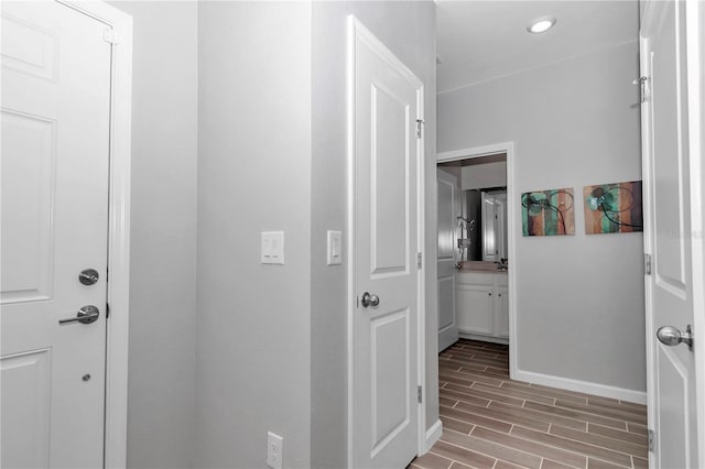 hallway featuring wood finish floors and baseboards