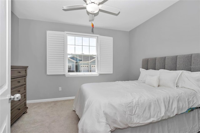 bedroom featuring light carpet, ceiling fan, and baseboards