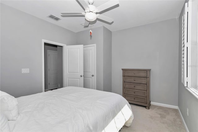 bedroom featuring visible vents, ceiling fan, baseboards, light carpet, and a closet