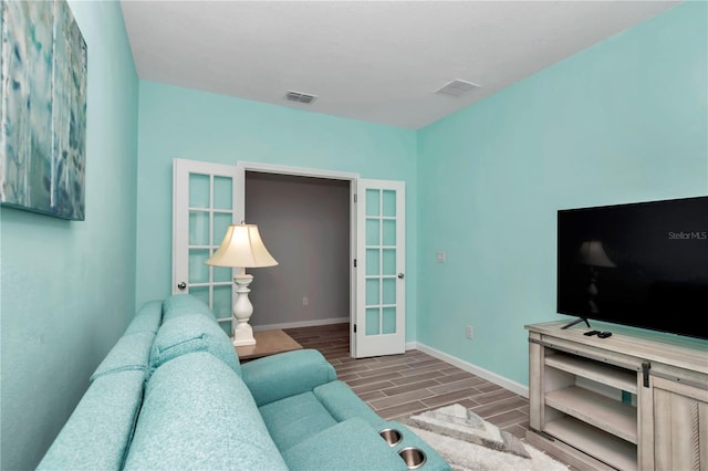 living area featuring visible vents, baseboards, and wood tiled floor