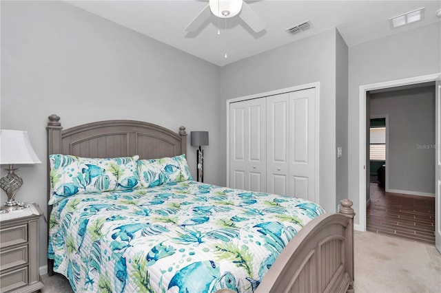 bedroom with visible vents, baseboards, light colored carpet, and a closet