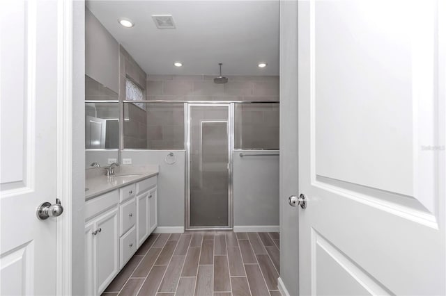 bathroom with vanity, visible vents, wood tiled floor, recessed lighting, and a stall shower