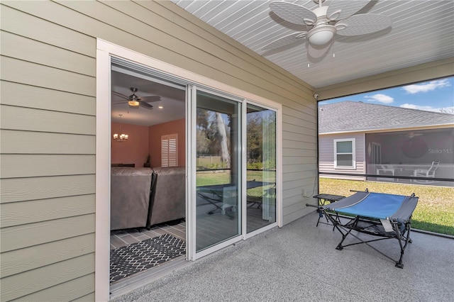 sunroom with ceiling fan with notable chandelier