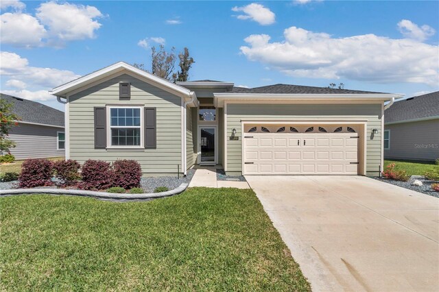 ranch-style house featuring an attached garage, a front lawn, and concrete driveway