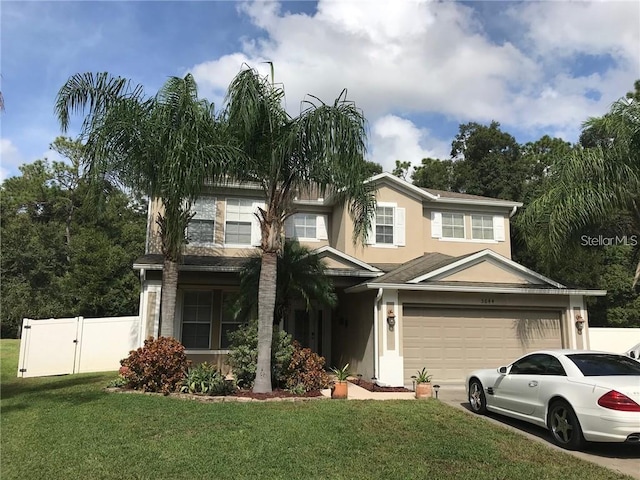 view of front of home featuring a garage, fence, a gate, stucco siding, and a front lawn