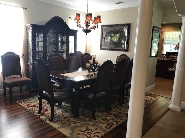 dining room featuring decorative columns, visible vents, ornamental molding, wood finished floors, and a chandelier