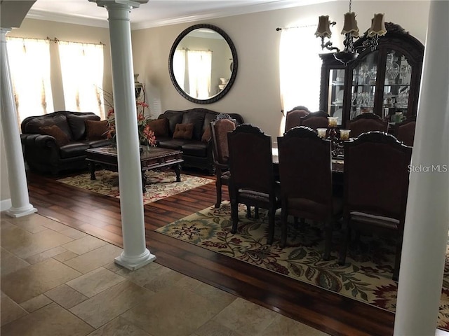 dining room with ornate columns, ornamental molding, a chandelier, and wood finished floors