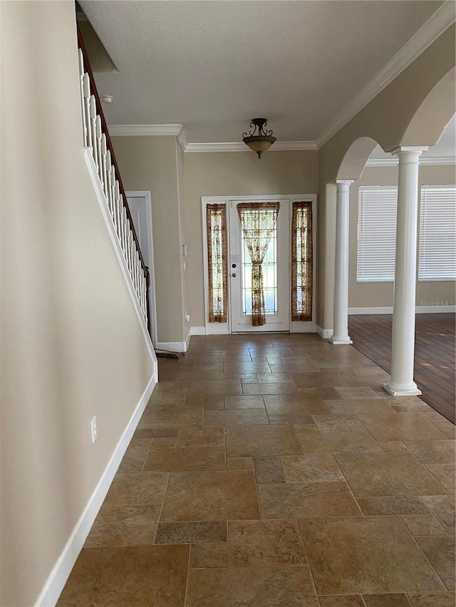 entrance foyer with decorative columns, arched walkways, and baseboards