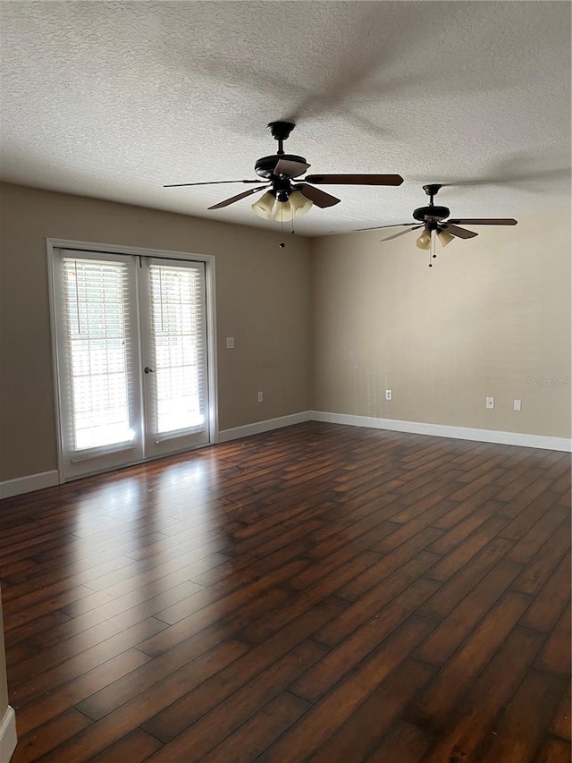 spare room featuring dark wood-type flooring and baseboards