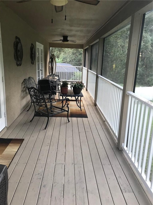 wooden terrace featuring a ceiling fan