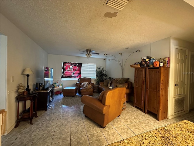 living room featuring visible vents, ceiling fan, and light tile patterned floors