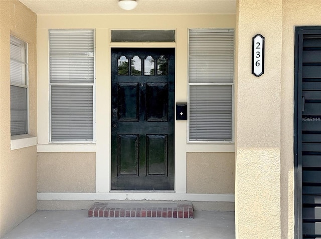 property entrance featuring stucco siding