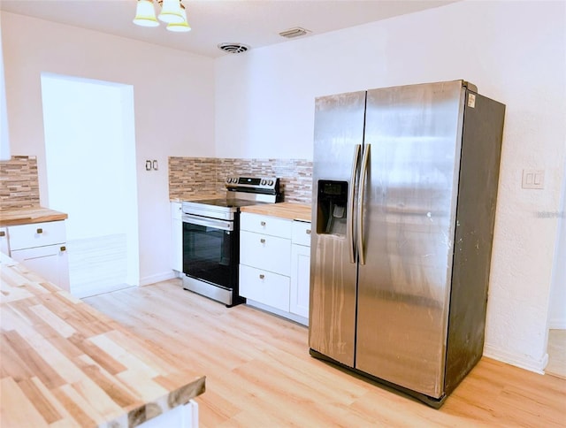 kitchen featuring visible vents, butcher block countertops, appliances with stainless steel finishes, and white cabinets