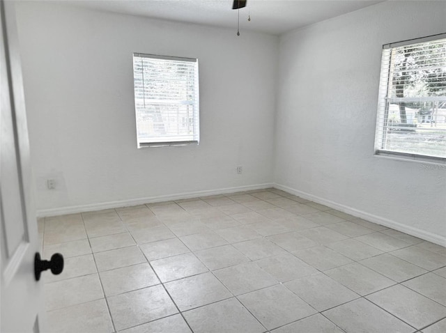 spare room featuring ceiling fan and baseboards