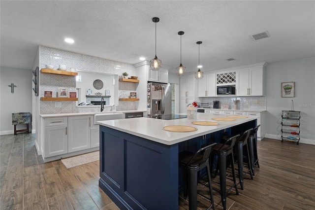 kitchen with visible vents, white cabinets, dark wood-style floors, black appliances, and open shelves