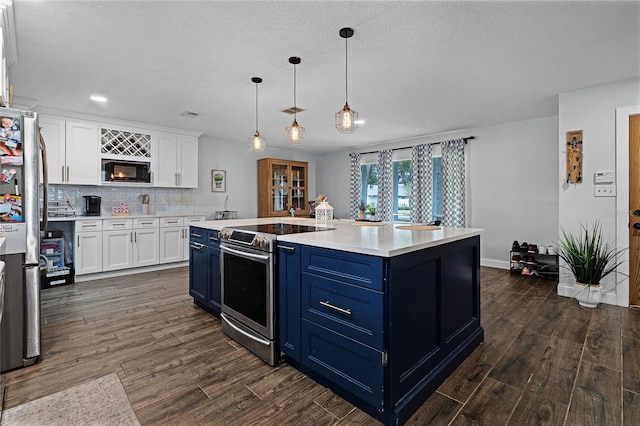 kitchen featuring white cabinetry, appliances with stainless steel finishes, blue cabinetry, decorative backsplash, and dark wood-style floors