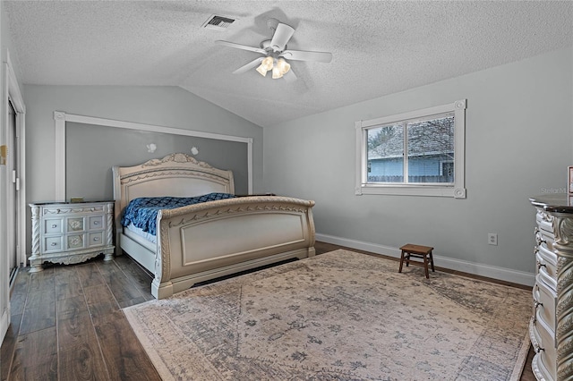 bedroom featuring dark wood-style floors, lofted ceiling, visible vents, a ceiling fan, and baseboards