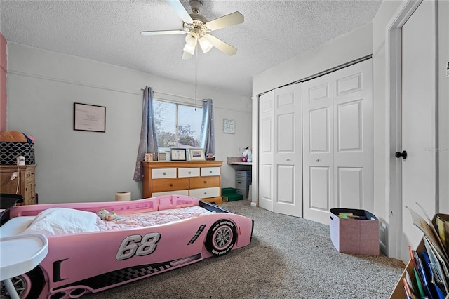 bedroom with carpet, a textured ceiling, ceiling fan, and a closet