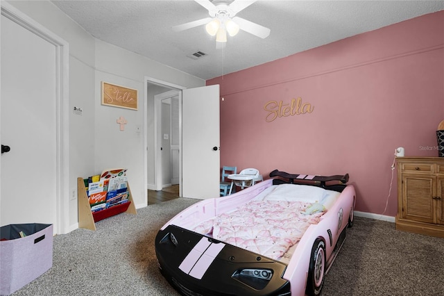 bedroom with a textured ceiling, visible vents, a ceiling fan, baseboards, and carpet