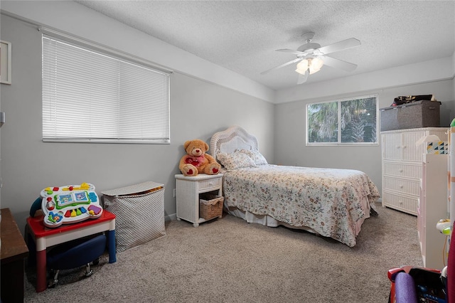 carpeted bedroom with a textured ceiling and ceiling fan