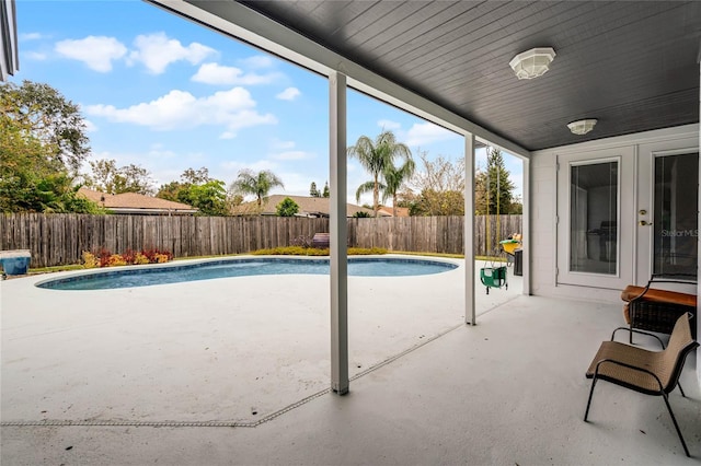 view of swimming pool featuring a fenced backyard, french doors, a fenced in pool, and a patio